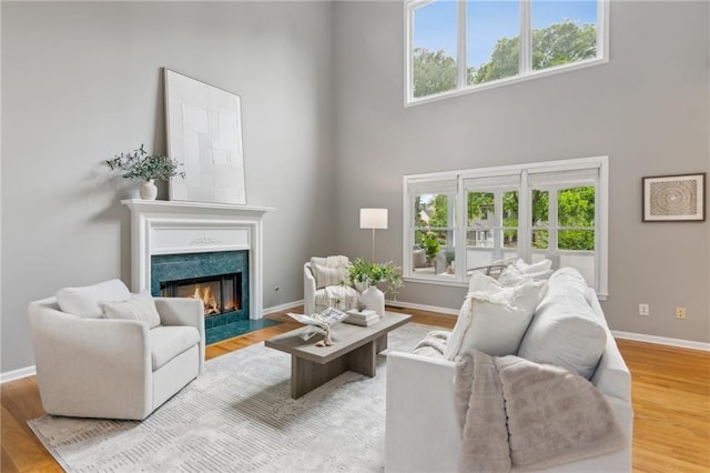 living area with baseboards, a wealth of natural light, and a towering ceiling
