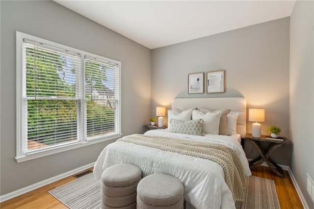 bedroom featuring visible vents, wood finished floors, and baseboards