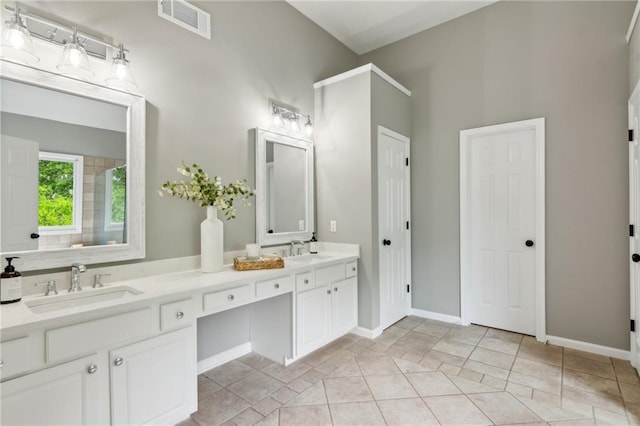 full bath with double vanity, visible vents, baseboards, and a sink