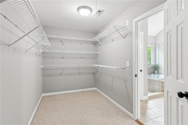walk in closet with visible vents and carpet floors
