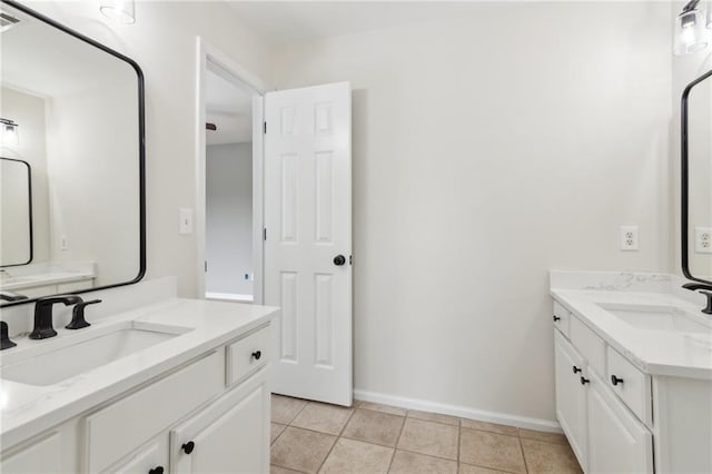 full bath featuring a sink, two vanities, baseboards, and tile patterned floors