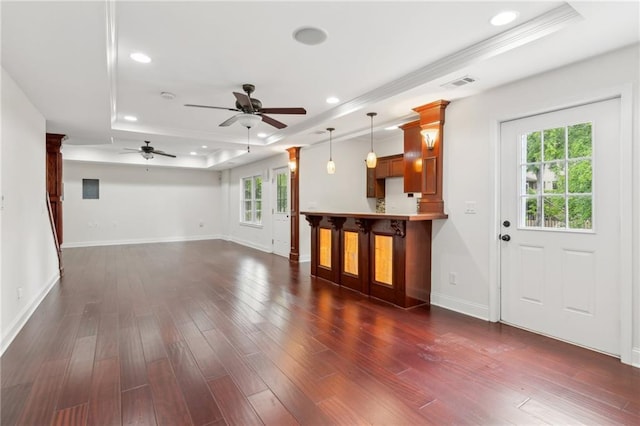 unfurnished living room featuring a ceiling fan, a raised ceiling, visible vents, and plenty of natural light