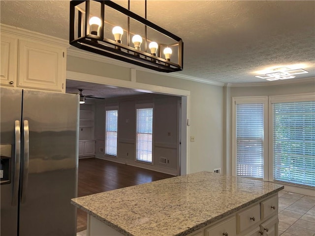 kitchen with white cabinetry, a textured ceiling, decorative light fixtures, and stainless steel refrigerator with ice dispenser