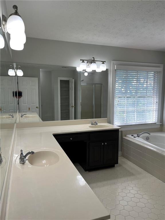 bathroom with vanity, a textured ceiling, tile patterned floors, and separate shower and tub