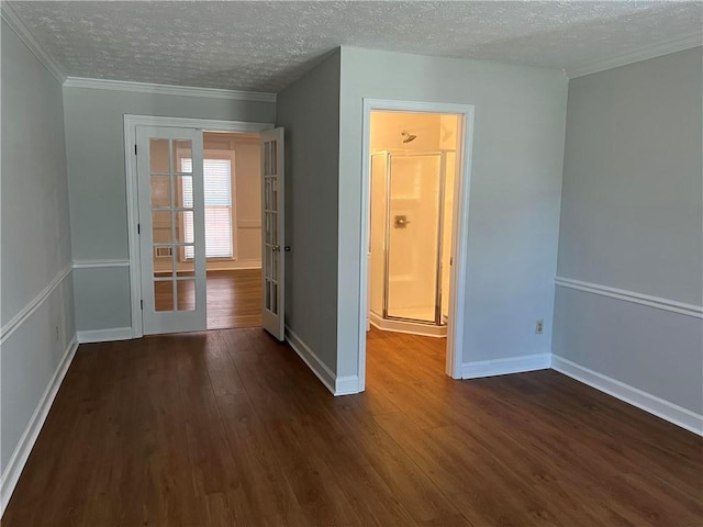 spare room with a textured ceiling, dark hardwood / wood-style flooring, and ornamental molding