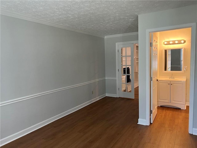 interior space featuring ensuite bathroom, sink, a textured ceiling, light hardwood / wood-style floors, and crown molding