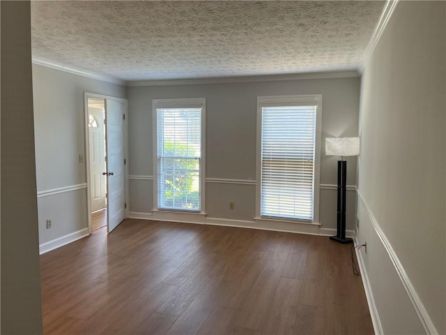 spare room with crown molding, a textured ceiling, and dark hardwood / wood-style flooring