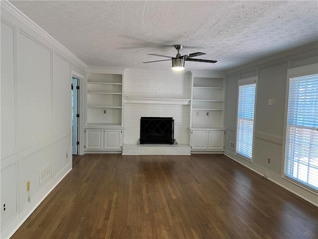 unfurnished living room with dark hardwood / wood-style floors, a textured ceiling, and a wealth of natural light