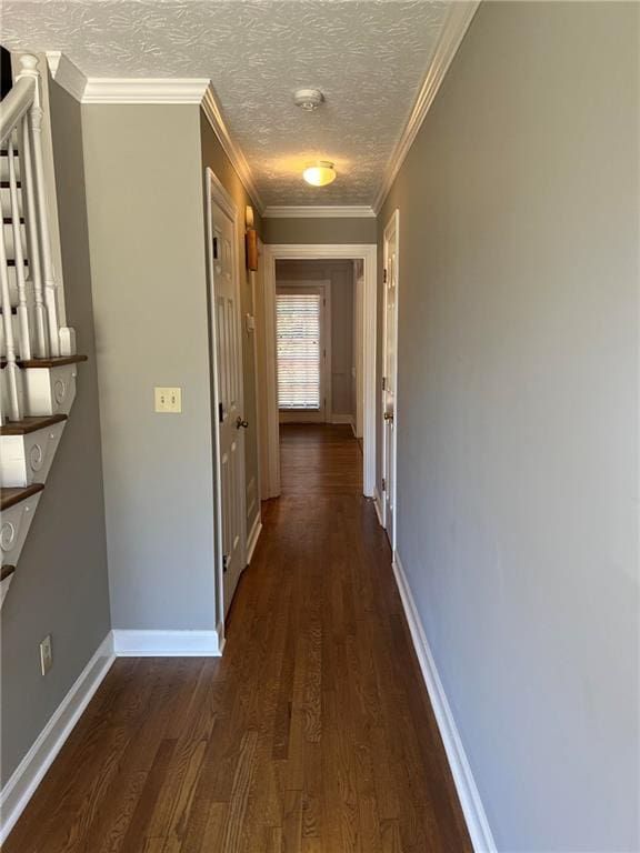 hall featuring crown molding, dark hardwood / wood-style floors, and a textured ceiling