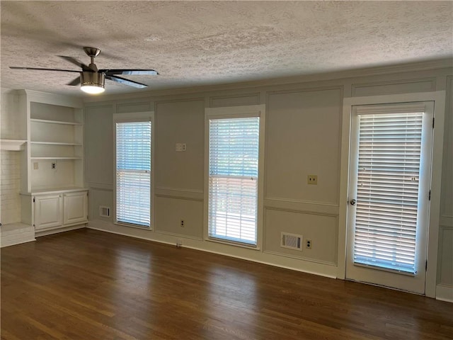 interior space featuring ceiling fan, a textured ceiling, and dark hardwood / wood-style flooring