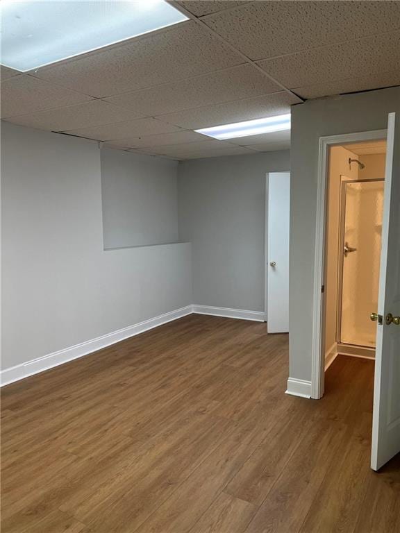 basement with hardwood / wood-style floors and a drop ceiling