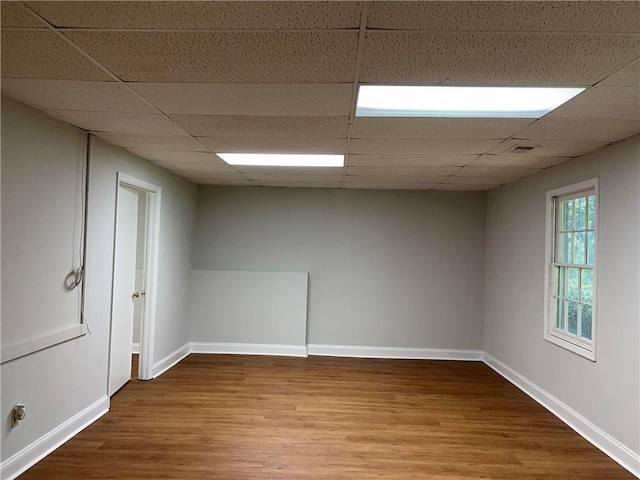 empty room with hardwood / wood-style floors and a paneled ceiling