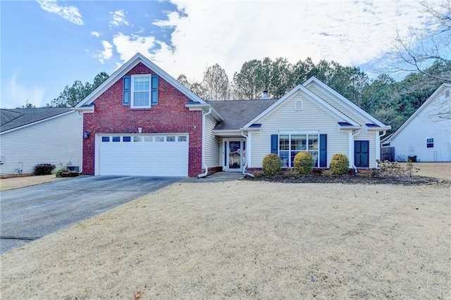 traditional-style home with a garage, brick siding, and driveway