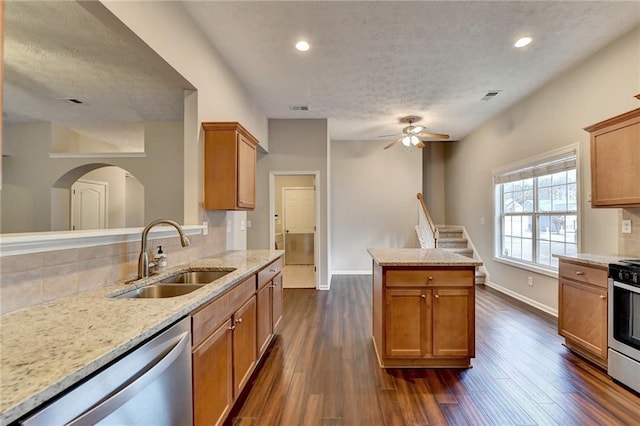 kitchen featuring baseboards, dark wood-style flooring, stainless steel appliances, and a sink