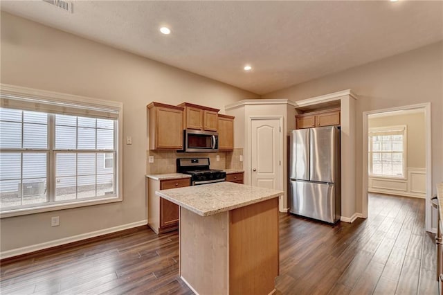 kitchen featuring stainless steel appliances, dark wood-style flooring, a kitchen island, and decorative backsplash