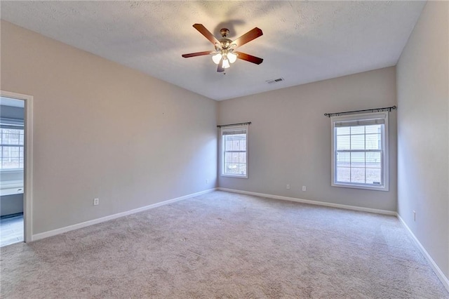 spare room with light colored carpet, visible vents, and baseboards