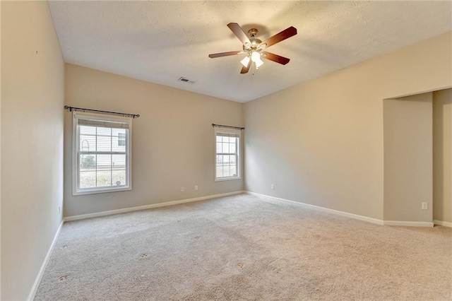 spare room with visible vents, light carpet, and baseboards