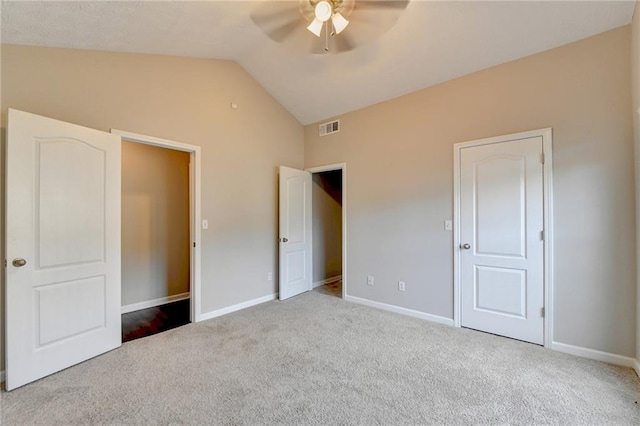 unfurnished bedroom with light colored carpet, lofted ceiling, visible vents, and baseboards