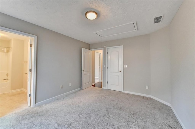 unfurnished bedroom with light carpet, baseboards, visible vents, and attic access