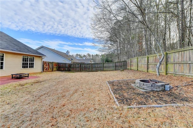 view of yard with a patio area, a fenced backyard, and a fire pit