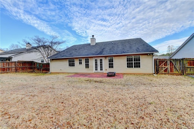 rear view of house featuring french doors, a patio, a chimney, a gate, and a fenced backyard