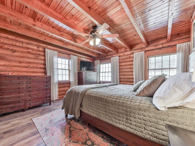 bedroom with beamed ceiling, wood finished floors, log walls, and wooden ceiling