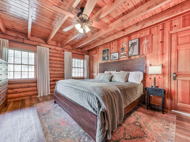 bedroom with wooden ceiling, rustic walls, wood finished floors, and beam ceiling