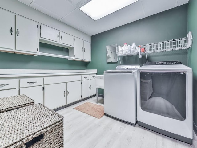 washroom featuring cabinet space, independent washer and dryer, and light wood-style floors