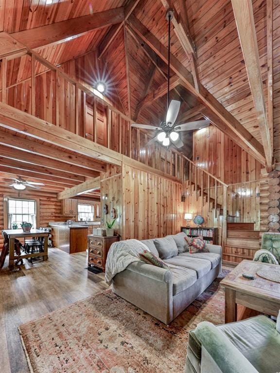 living area with beam ceiling, high vaulted ceiling, and ceiling fan