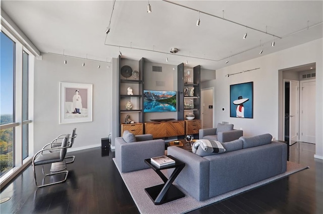 living room featuring track lighting, expansive windows, and dark wood-type flooring