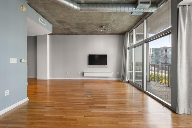 943 Peachtree St NE Unit 1109, Atlanta, GA 30309 - unfurnished living room featuring floor to ceiling windows and wood-type flooring