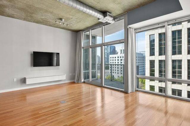 943 Peachtree St NE Unit 1109, Atlanta, GA 30309 - unfurnished living room with plenty of natural light, expansive windows, and hardwood / wood-style flooring