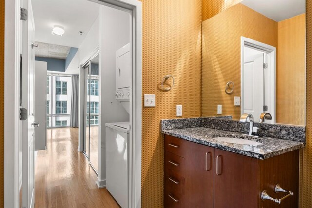 943 Peachtree St NE Unit 1109, Atlanta, GA 30309 - bathroom with vanity, wood-type flooring, and stacked washer / dryer