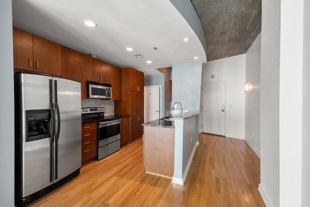943 Peachtree St NE Unit 1109, Atlanta, GA 30309 - kitchen with sink, decorative backsplash, a center island with sink, appliances with stainless steel finishes, and light wood-type flooring