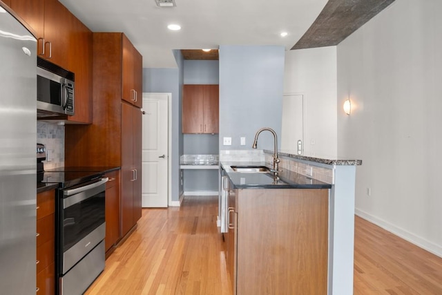 943 Peachtree St NE Unit 1109, Atlanta, GA 30309 - kitchen featuring decorative backsplash, sink, light wood-type flooring, and stainless steel appliances
