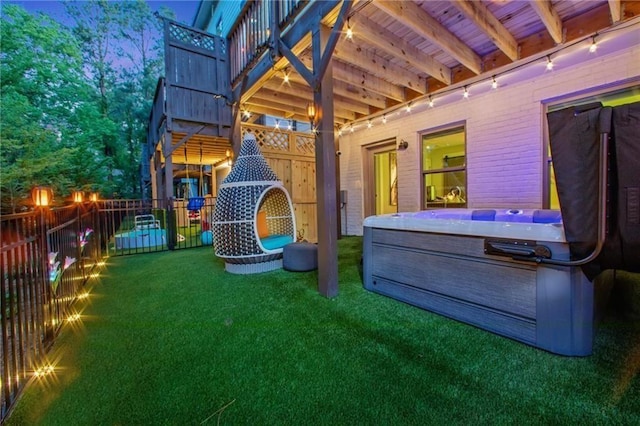 view of jungle gym with a hot tub and a yard