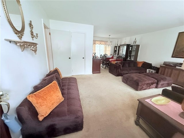 carpeted living room with an inviting chandelier