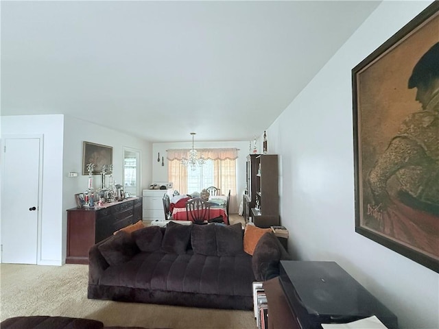living area with carpet floors, washer / dryer, and an inviting chandelier