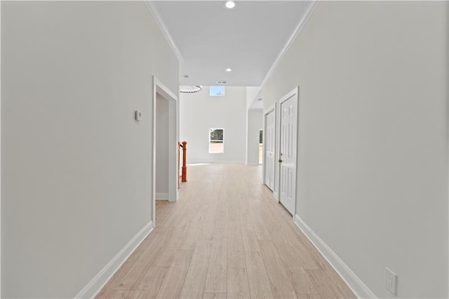 hall with light wood-type flooring and crown molding