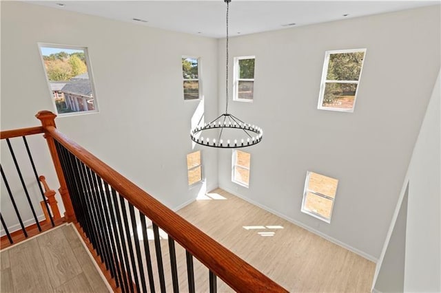 staircase featuring an inviting chandelier and hardwood / wood-style floors