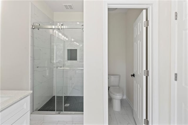 bathroom with toilet, a shower with shower door, and vanity