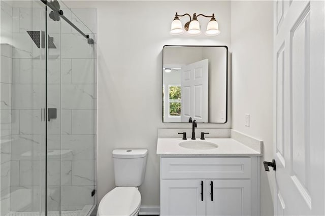 bathroom featuring toilet, an enclosed shower, and vanity