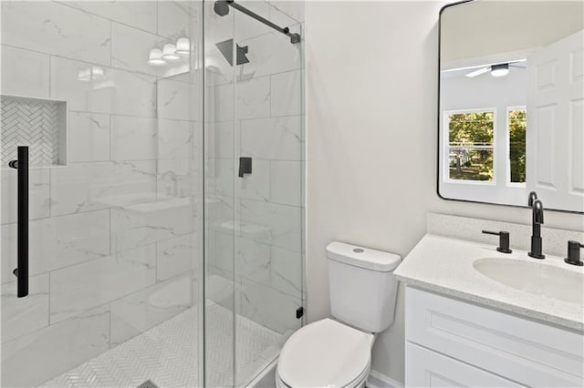 bathroom featuring an enclosed shower, vanity, and toilet