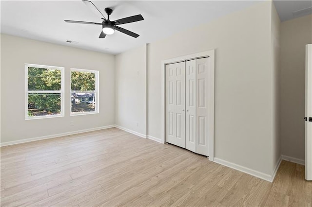 unfurnished bedroom featuring a closet, ceiling fan, and light hardwood / wood-style flooring