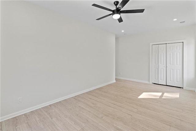 unfurnished bedroom with ceiling fan, light hardwood / wood-style flooring, and a closet