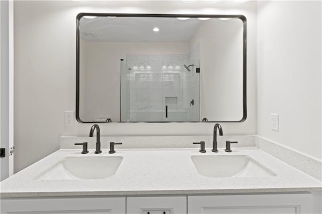 bathroom with a shower with door and vanity