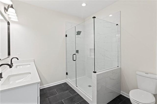 bathroom featuring toilet, vanity, tile patterned flooring, and a shower with shower door