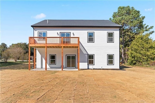 back of property featuring a deck, a patio area, and a yard