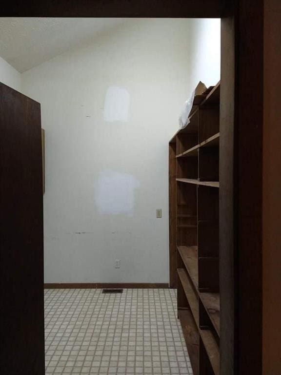 mudroom with lofted ceiling and tile flooring