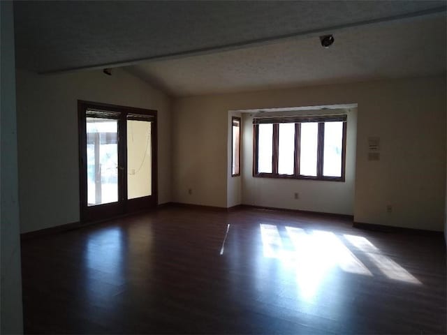 unfurnished room with lofted ceiling, french doors, and dark hardwood / wood-style flooring